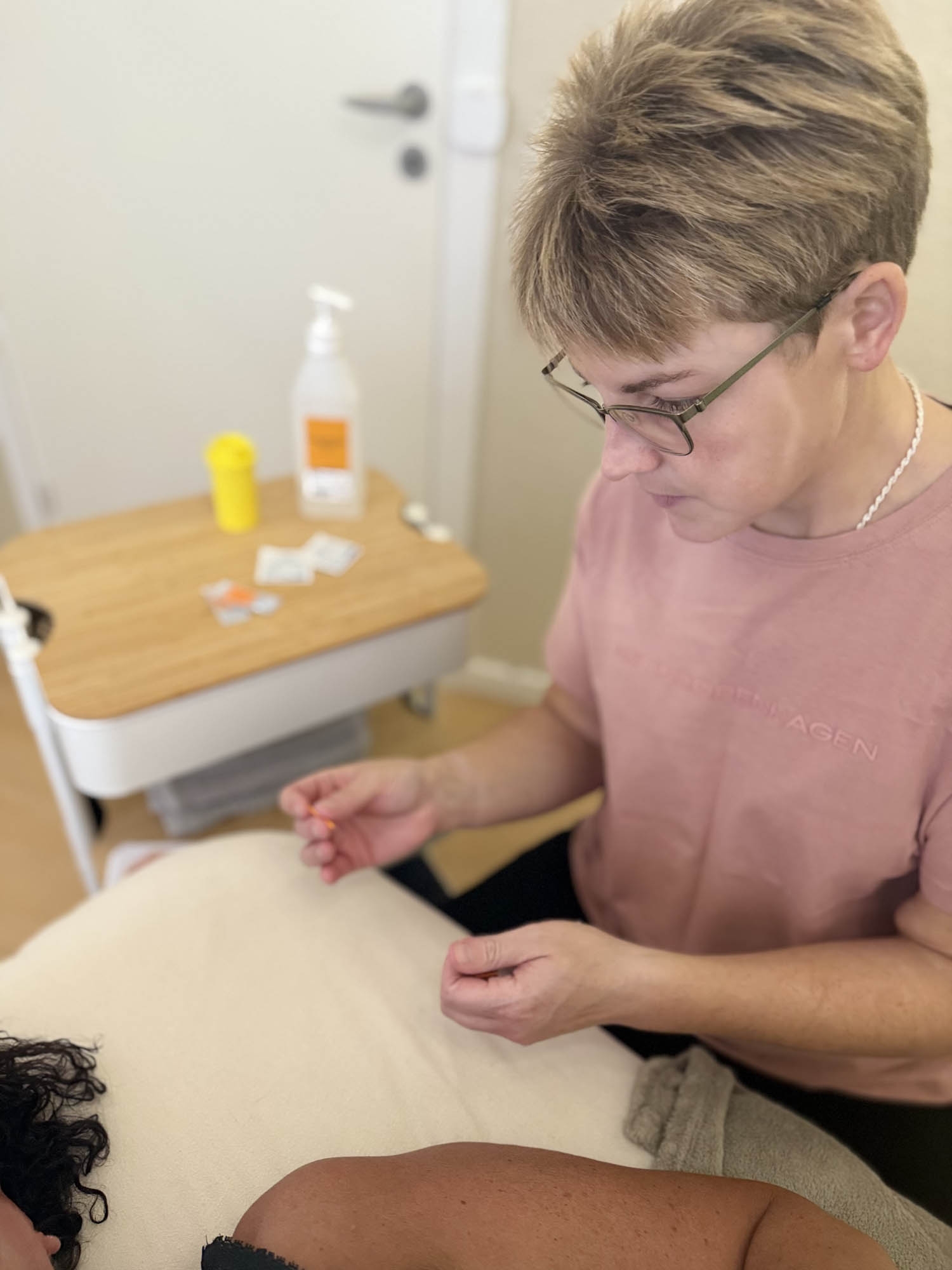 Akupunktør udfører akupunktur behandling hos klinik i Odense